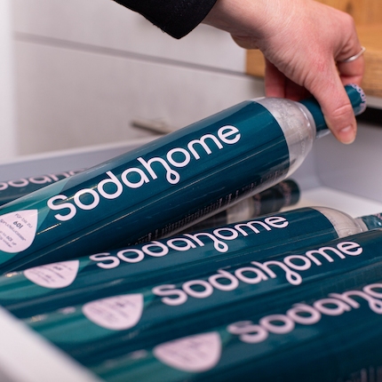 Aufbewahrung Sodahome CO₂-Zylinder Schublade Mehrere Sodahome CO₂-Zylinder werden liegend in einer Schublade aufbewahrt. Es ist eine Hand zu sehen, welche einen Zylinder aus der Schublade nimmt.